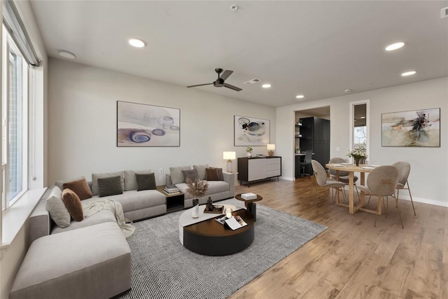 living room featuring ceiling fan and light wood-type flooring