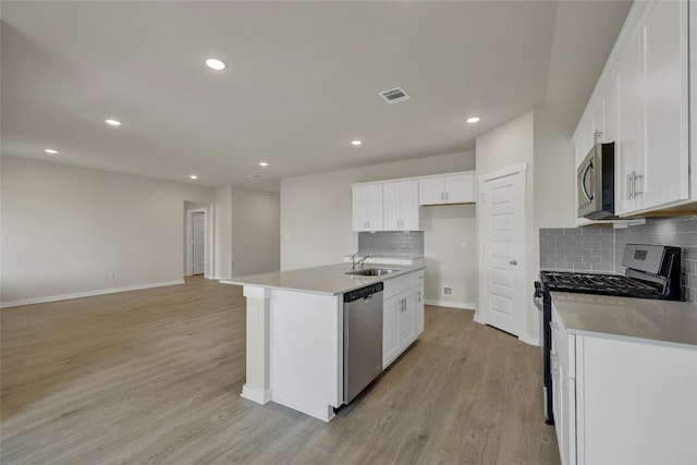 650 Radley Rd, Lockhart, TX 78644 - kitchen with an island with sink, appliances with stainless steel finishes, sink, and white cabinets