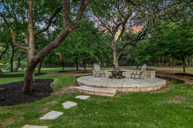 yard at dusk featuring a patio and an outdoor fire pit