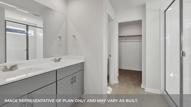 bathroom featuring vanity, a shower with shower door, and wood-type flooring