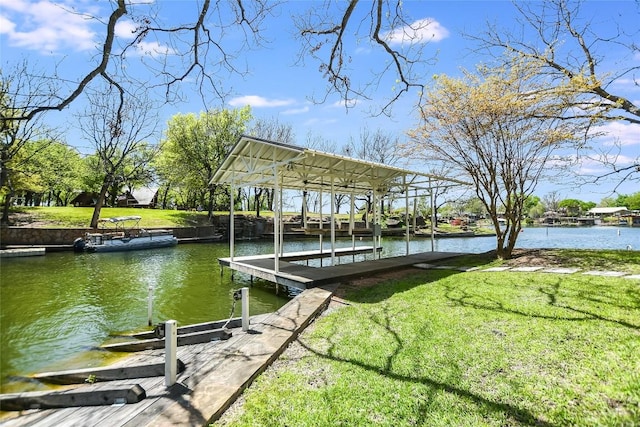 view of dock with a lawn and a water view