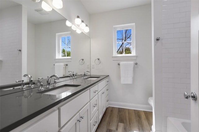 bathroom with hardwood / wood-style flooring, vanity, and toilet