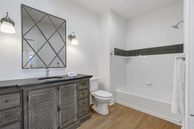 full bathroom featuring hardwood / wood-style flooring, vanity, shower / tub combo, and toilet