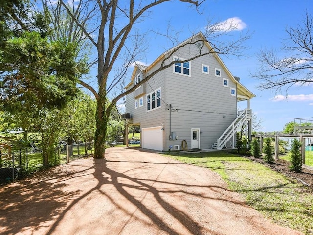 1332 S Lakeside Dr, Kingsland, TX 78611 - view of home's exterior featuring stairs, dirt driveway, and a garage