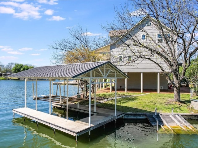 view of dock with a lawn and a water view