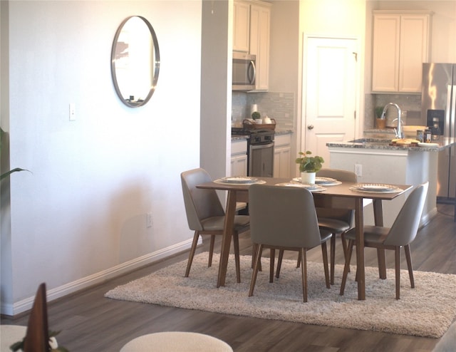 dining area featuring dark hardwood / wood-style flooring and sink