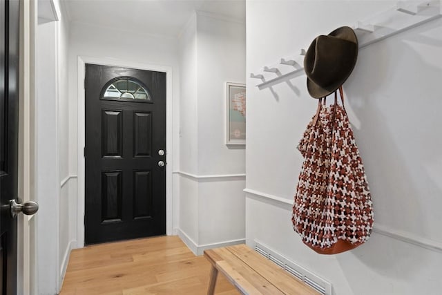 foyer entrance featuring crown molding and light hardwood / wood-style floors