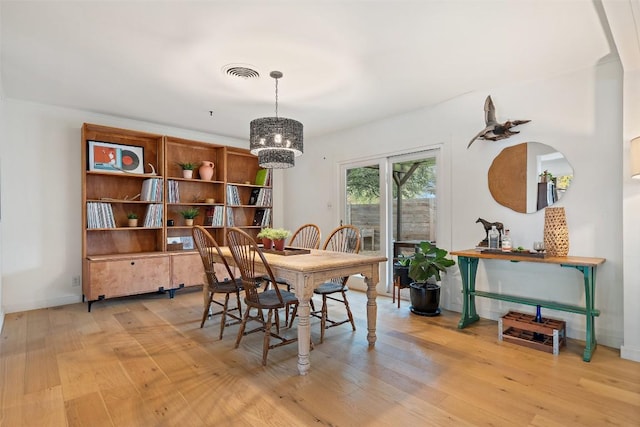 dining room with an inviting chandelier and light hardwood / wood-style floors