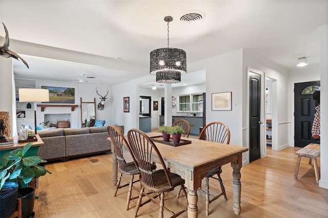 dining room featuring light wood-style flooring, visible vents, and baseboards