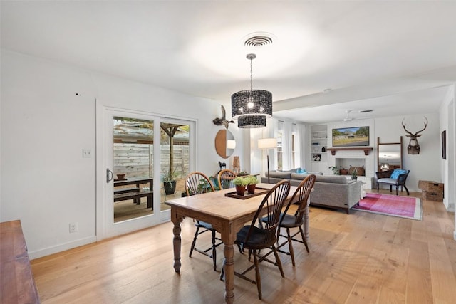 dining room with built in shelves and light wood-type flooring