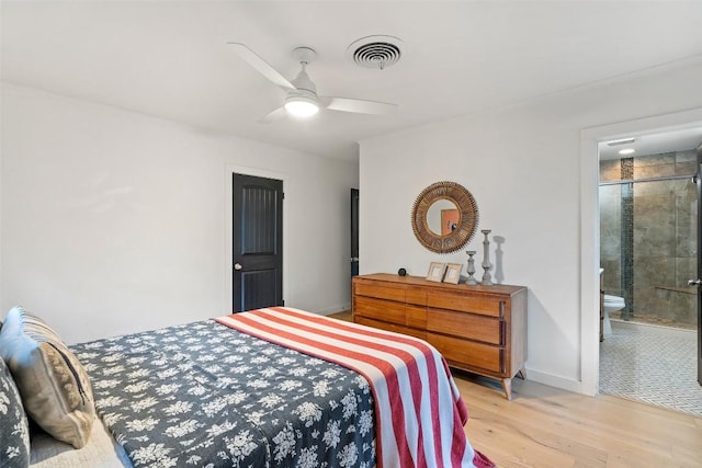 bedroom with light wood finished floors, visible vents, ceiling fan, ensuite bath, and baseboards