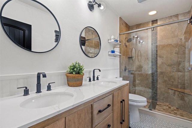 bathroom featuring vanity, toilet, and a shower with door