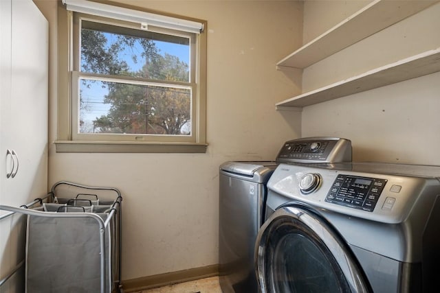 clothes washing area featuring washing machine and dryer, laundry area, and baseboards