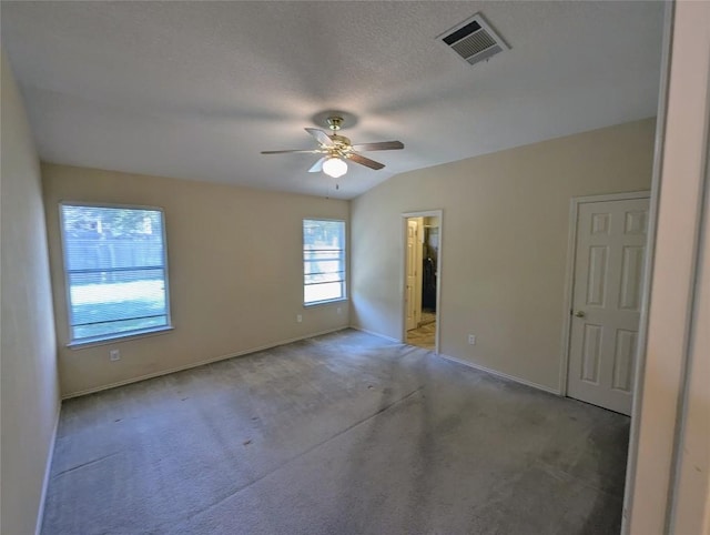 carpeted empty room with lofted ceiling, a textured ceiling, and ceiling fan