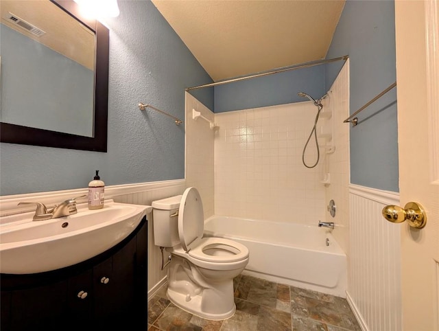 full bathroom with vanity, tiled shower / bath combo, and toilet