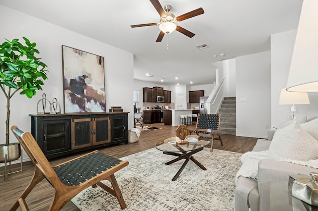 living room featuring dark hardwood / wood-style flooring and ceiling fan