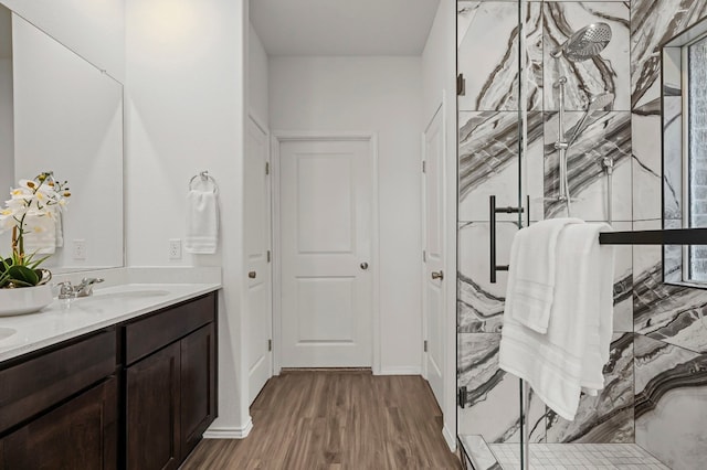 bathroom featuring walk in shower, vanity, and wood-type flooring