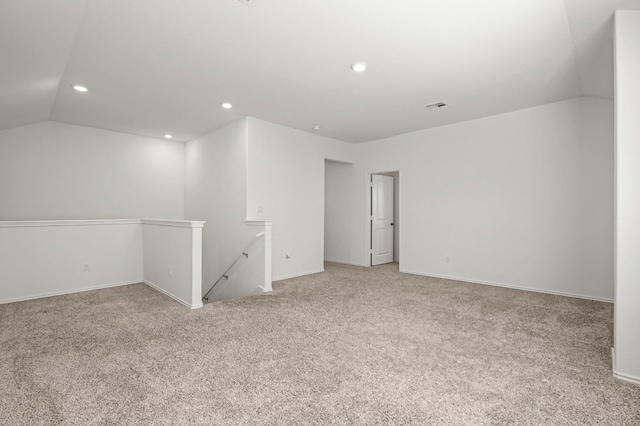 empty room featuring vaulted ceiling and light carpet