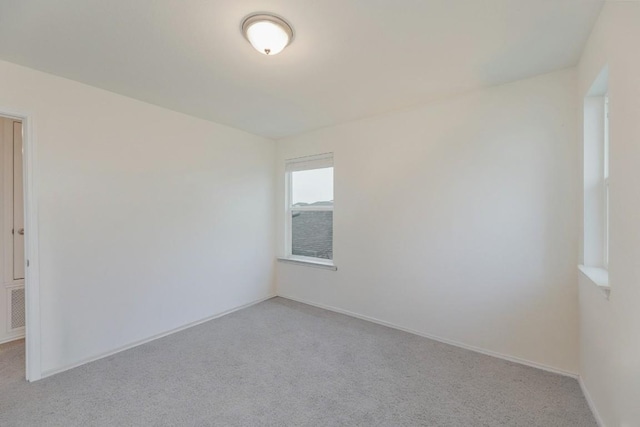 spare room featuring light colored carpet