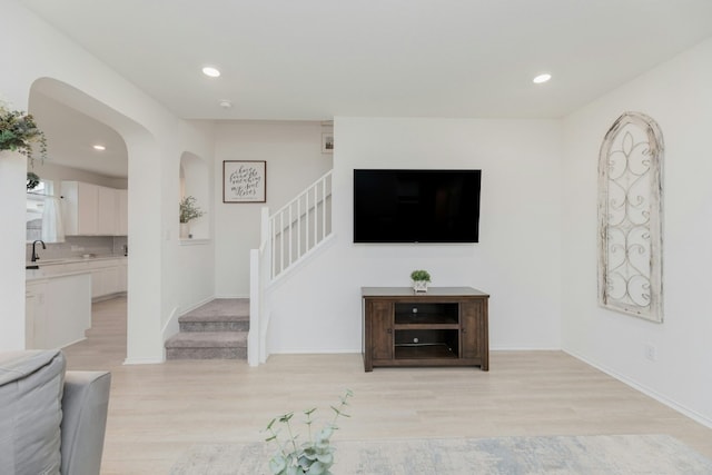 living room with sink and light hardwood / wood-style flooring