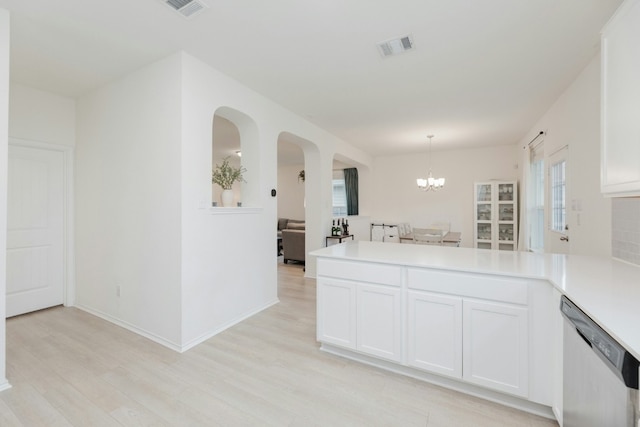 kitchen with pendant lighting, white cabinetry, an inviting chandelier, light hardwood / wood-style floors, and stainless steel dishwasher