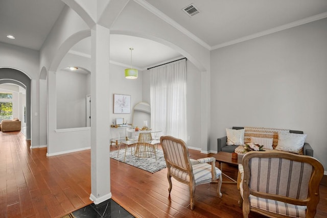 sitting room with ornamental molding and wood-type flooring