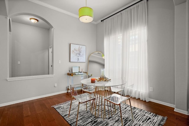 dining space with dark wood-type flooring and ornamental molding