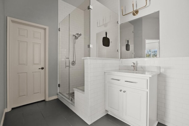 bathroom featuring tile patterned floors, an enclosed shower, tile walls, and vanity