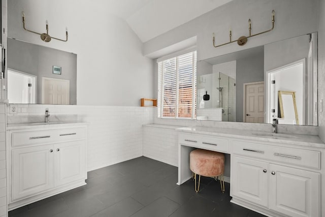 bathroom with vanity, vaulted ceiling, tile walls, and an enclosed shower