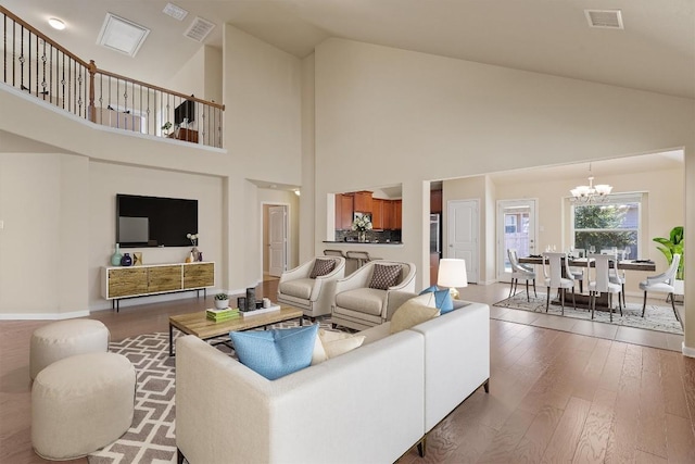 living room with hardwood / wood-style flooring, vaulted ceiling, and a notable chandelier