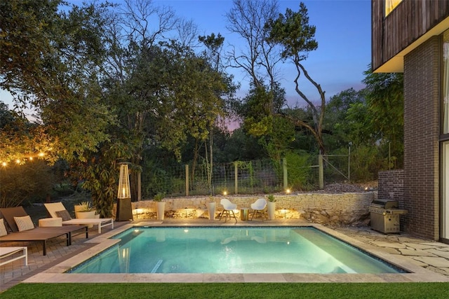 pool at dusk with a patio