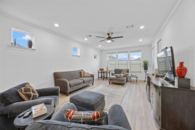 living room with crown molding, ceiling fan, and light hardwood / wood-style floors