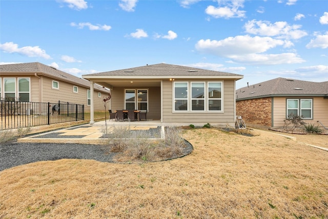 back of property with a patio and a yard