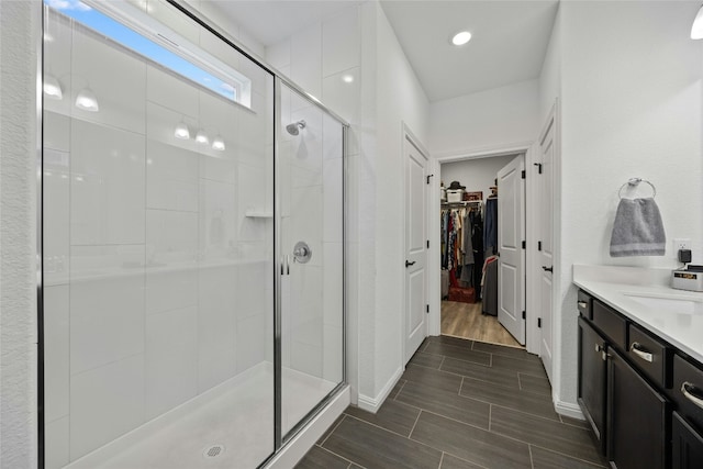722 Kitty Hawk Rd, Georgetown, TX 78633 - full bathroom featuring a stall shower, a spacious closet, vanity, and wood finish floors