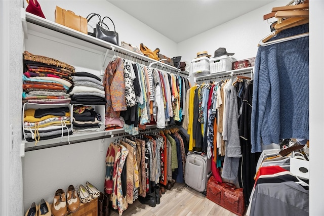 walk in closet with light hardwood / wood-style floors