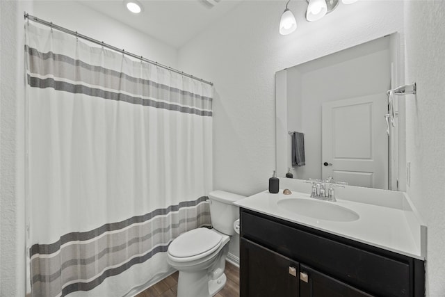 bathroom featuring wood-type flooring, vanity, and toilet