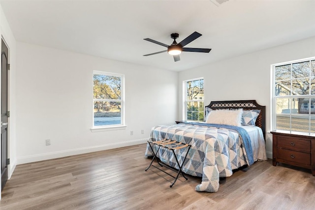 bedroom with a ceiling fan, baseboards, and wood finished floors