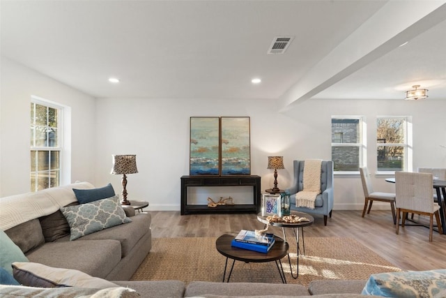 living room featuring recessed lighting, wood finished floors, visible vents, and baseboards