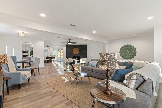 living room with ceiling fan and light hardwood / wood-style flooring