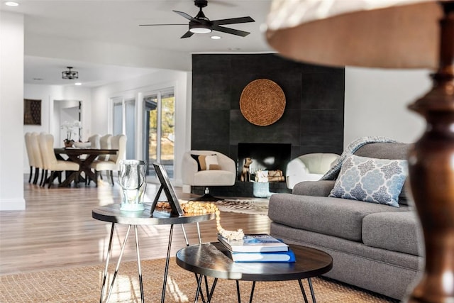 living room featuring baseboards, a ceiling fan, wood finished floors, a fireplace, and recessed lighting