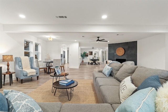 living area with baseboards, recessed lighting, visible vents, and light wood-style floors