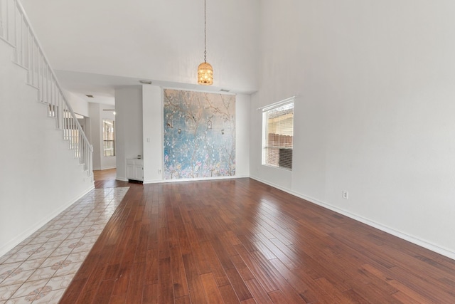 interior space featuring wood-type flooring and a high ceiling