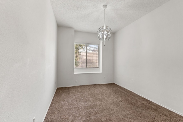 empty room featuring carpet floors, an inviting chandelier, and a textured ceiling