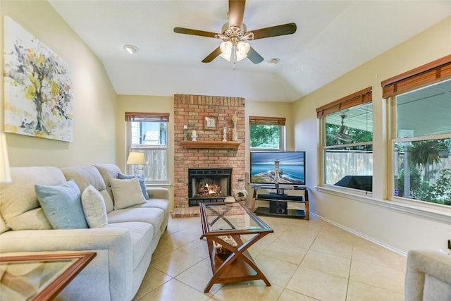 tiled living room with ceiling fan, lofted ceiling, and a brick fireplace