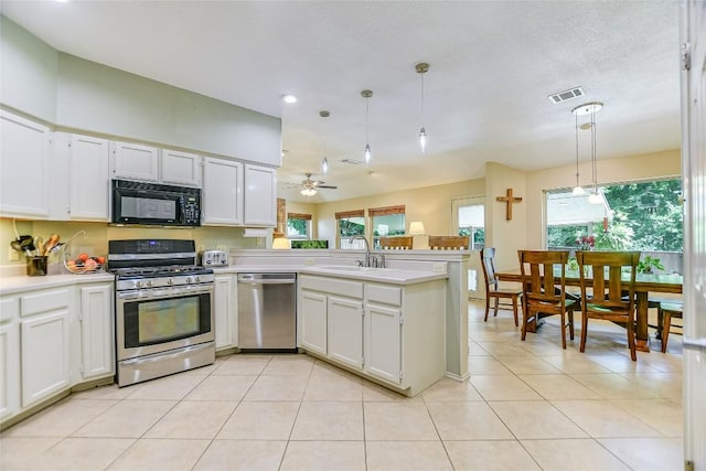 kitchen featuring sink, decorative light fixtures, appliances with stainless steel finishes, kitchen peninsula, and white cabinets