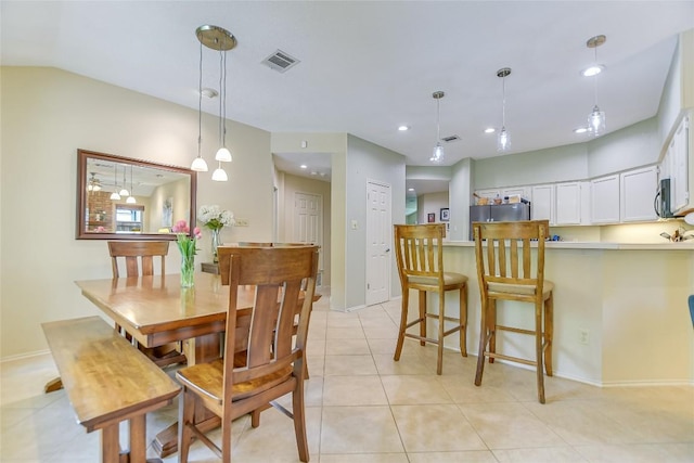 tiled dining space with lofted ceiling