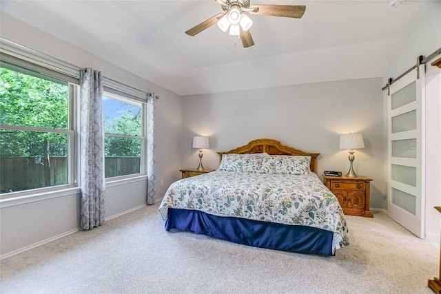 carpeted bedroom featuring ceiling fan, a barn door, and vaulted ceiling