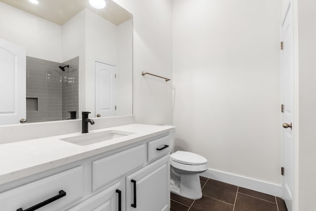 bathroom with tile patterned floors, toilet, vanity, and a tile shower