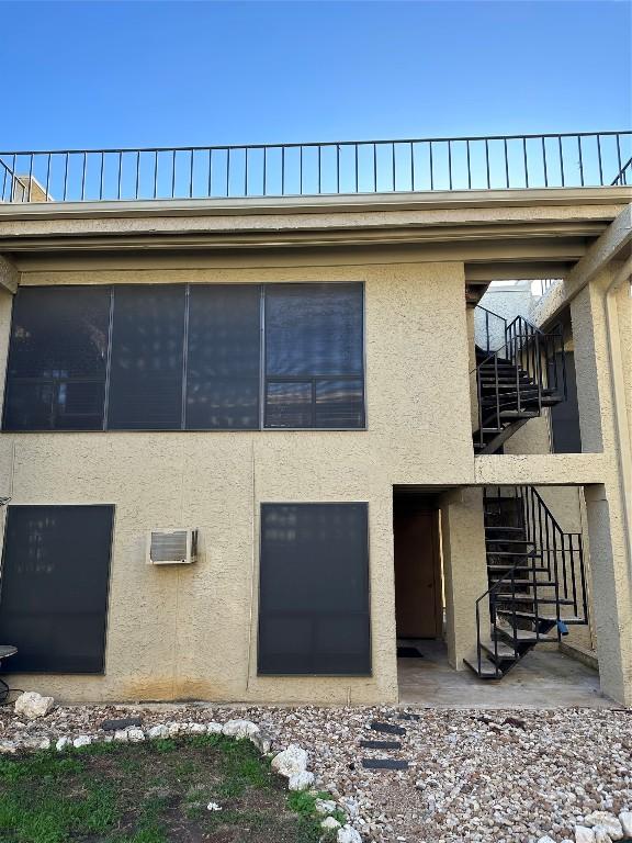 rear view of house featuring a wall mounted air conditioner and a patio