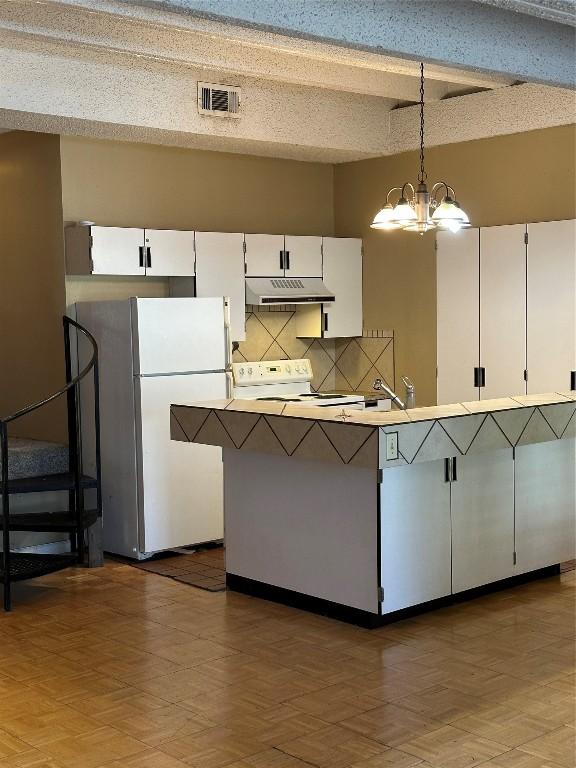 kitchen with white cabinetry, hanging light fixtures, a notable chandelier, white appliances, and decorative backsplash